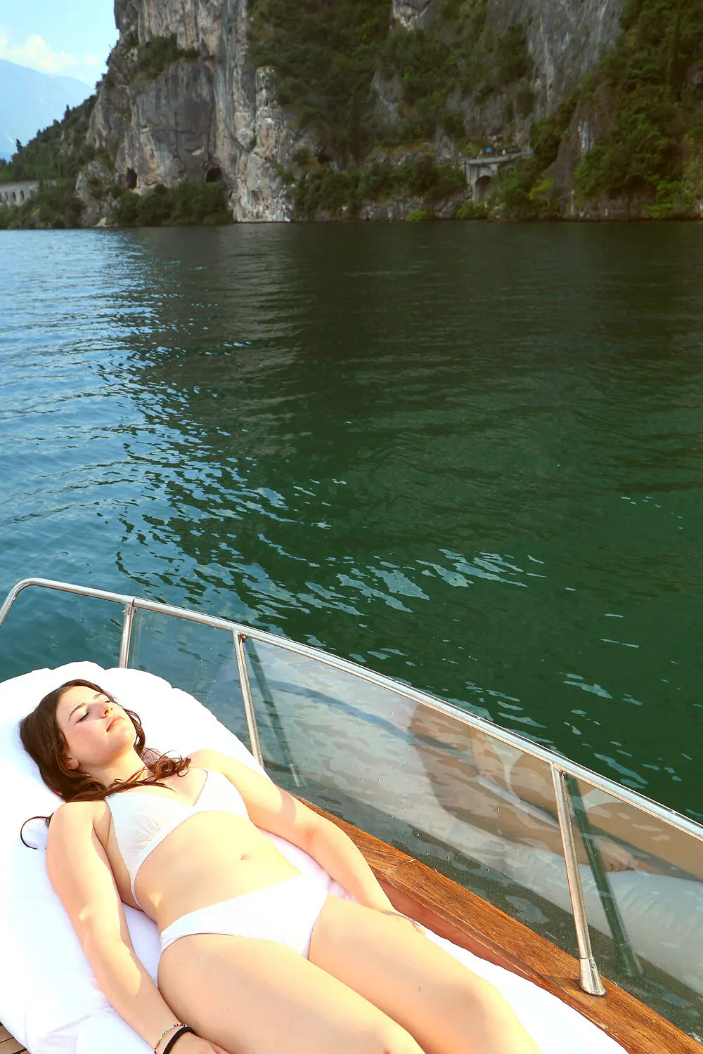 Relax alla ringhiera della barca tra le pareti rocciose del Garda